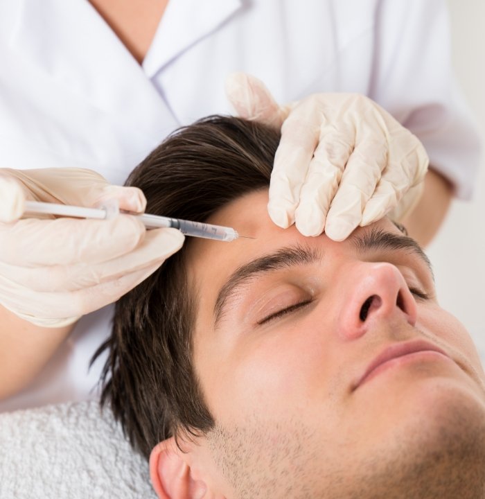 Man receiving a Botox injection in his forehead