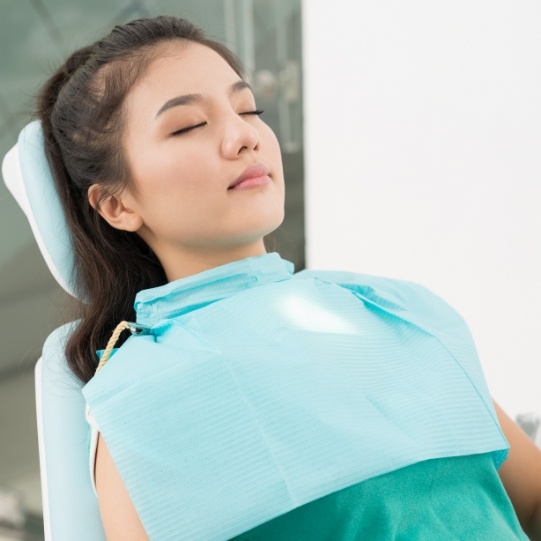 Woman relaxing in dental chair thanks to sedation dentistry in Mansfield