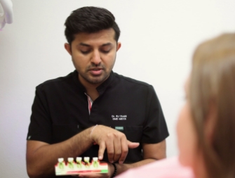 Dental office receptionist showing a patient where to sign on a clipboard