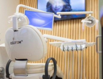 patient smiling at team member while laying in dental chair in Mansfield